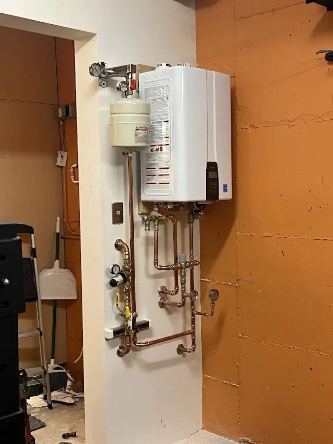 Plumbing technician inspecting water heater connections in Jourdanton